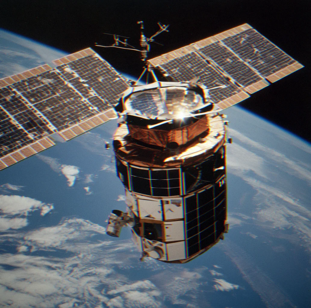 Skylab in orbit with solar panels out, photographed from the Skylab 4 spacecraft with Earth below